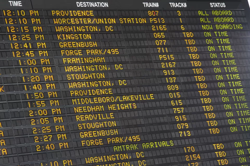 Close-up of old-fashioned trains departure board with yellow text on black background in Boston, Massachusetts train station.